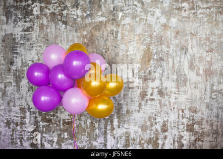 Bouquet de ballons lumineux contre un mur texturé. Copy space Banque D'Images