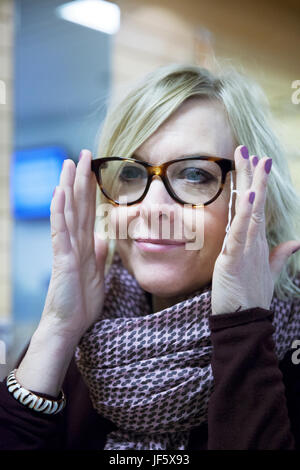 Woman trying on glasses in optométristes shop Banque D'Images