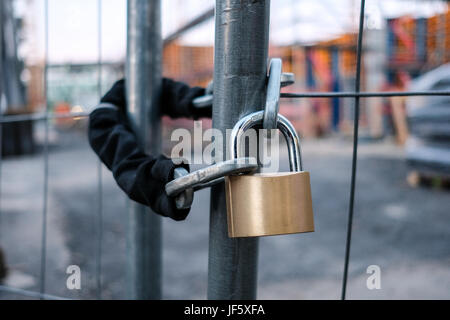 Chaîne et cadenas sur gate at construction site - verrou sur une clôture fermée Banque D'Images