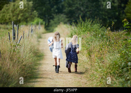 Les filles marcher sur chemin de terre Banque D'Images