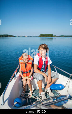 Boy and girl sitting in boat Banque D'Images