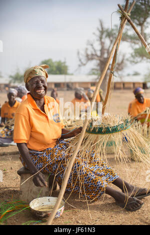 Les femmes d'une coopérative du tisserand traditionnel tisser des paniers de paille ensemble dans la région du nord-est, au Ghana. Banque D'Images