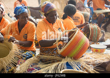 Les femmes d'une coopérative du tisserand traditionnel tisser des paniers de paille ensemble dans la région du nord-est, au Ghana. Banque D'Images