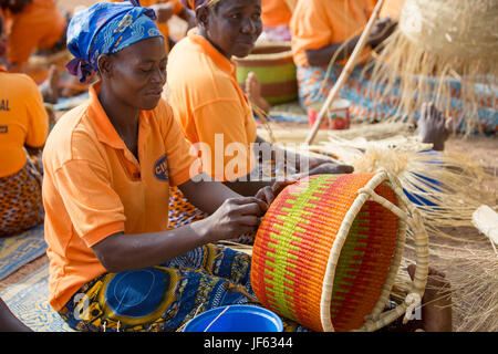 Les femmes d'une coopérative du tisserand traditionnel tisser des paniers de paille ensemble dans la région du nord-est, au Ghana. Banque D'Images