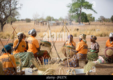 Les femmes d'une coopérative du tisserand traditionnel tisser des paniers de paille ensemble dans la région du nord-est, au Ghana. Banque D'Images