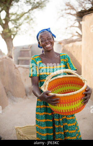 Une femme est titulaire d'un panier de paille traditionnel dans la région du nord-est, au Ghana. Banque D'Images