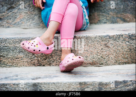 Girl sitting on steps avec jambes croisées Banque D'Images