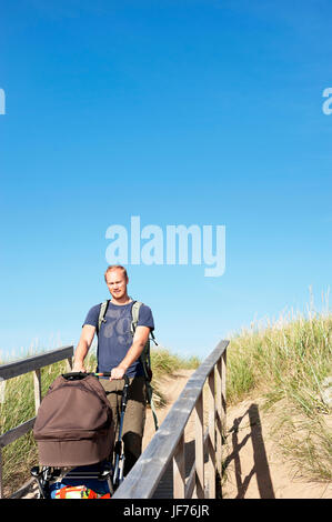 Man pushing baby carriage sur passerelle Banque D'Images