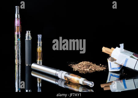 E-cigarette avec pile de feuilles de tabac broyé et un paquet de cigarettes Banque D'Images