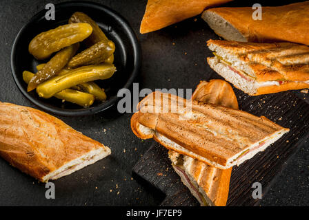 La nourriture traditionnelle cubaine, snack, cuisine de fête. Sandwich cubain de baguette au jambon, porc, fromage, cornichons. Sur le tableau noir de l'espace de copie Banque D'Images