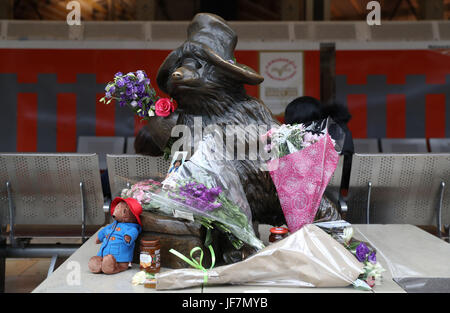 Des fleurs et des pots de confiture sont laissés par l'ours Paddington statue à l'intérieur la gare de Paddington, Londres, après créateur Michael Bond est décédé le mardi à l'âge de 91 ans. Banque D'Images