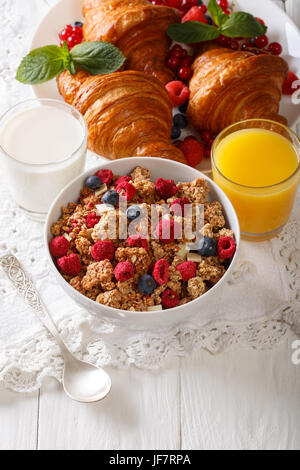 L'alimentation saine : granola multigrains, de croissants, de baies fraîches, lait et jus d'orange sur la table verticale. Banque D'Images