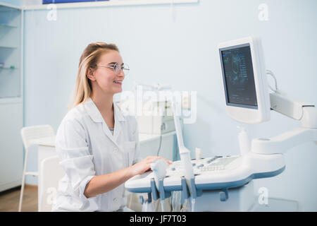 Smiling doctor, échographie. Le médecin effectue une échographie Banque D'Images