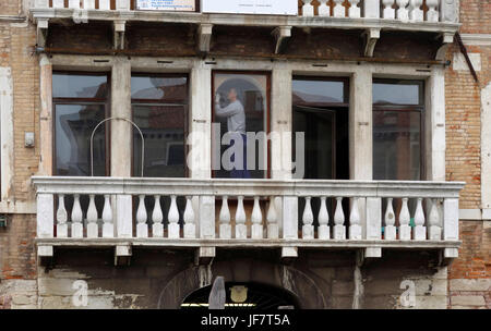 Restaurateur de travailler à l'intérieur d'un bâtiment le long du Grand Canal, Venise, Italie Banque D'Images
