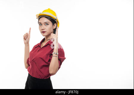 Ingénieur femme asiatique en chemise rouge et jaune bouchon de sécurité pointant au-dessus d'une émotion. Les gens gesticulant dans les affaires et enginerring concept Banque D'Images