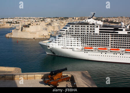 Tourisme de masse en Méditerranée. Le grand navire de croisière ou navire de croisière MSC Meraviglia naine le fort St Angelo (en haut à gauche) au départ de Malte, en Europe Banque D'Images