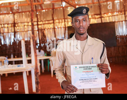 Les stagiaires de police détiennent des certificats qu'ils ont reçues pendant un cours de protection rapprochée menée par la Mission de l'Union africaine en Somalie (AMISOM), à Kismayo Somalie le 20 mai 2017. Photo de l'AMISOM Banque D'Images