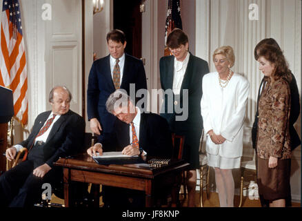 Le président des États-Unis, Bill Clinton signe la 'loi' Brady lors d'une cérémonie dans la East Room de la Maison Blanche à Washington, D.C. le 30 novembre 1993. De gauche à droite : l'ancien secrétaire de presse de la Maison Blanche James S. Brady, Vice président américain Al Gore, le Président Clinton des États-Unis ; le procureur général Janet Reno ; Sarah Brady, épouse de James Brady ; et Melanie Musick, dont le mari a été tué par une arme à la main. Brady est décédé lundi 4 août, 2014. Credit : Ron Sachs / CNP /MediaPunch Banque D'Images