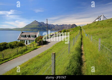 Île de Skye, UK - 20 juin 2017 : vue sur la chaîne de montagnes Cuillin noires sur le Loch Scavaig depuis le sentier littoral près de Elgol avec maison traditionnelle Banque D'Images