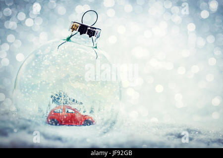 Bille de verre de Noël dans la neige avec l'hiver à l'intérieur du monde miniature - voiture avec arbre de Noël, les montagnes. Glitter. Banque D'Images