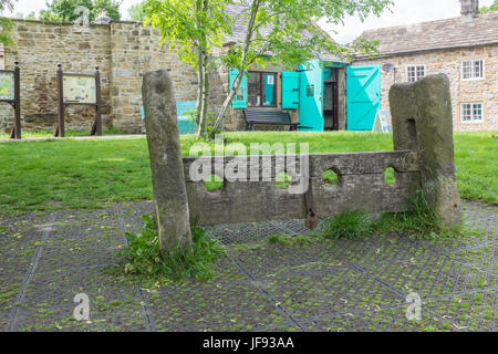 Vieux stocks sur le village vert dans Eyam dans le Derbyshire Peak District Banque D'Images