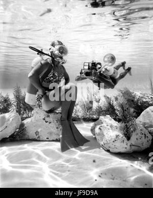 Plongeur et photographe capturé en action au Cypress Gardens à Winter Haven, en Floride, au milieu du XXe siècle, mettant en valeur la photographie sous-marine. Banque D'Images
