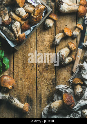 Champignons des bois blanc fraîchement cueillies, les feuilles, le couteau sur fond de bois Banque D'Images