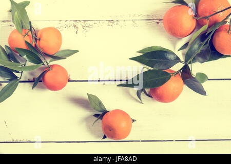 Mandarine avec des feuilles sur la table en bois blanc Banque D'Images