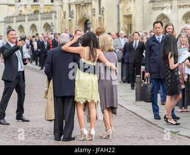 Cambridge, UK. 30 juin 2017. Heureux parents posent pour une photo en face de la file d'attente des parents, proches et amis d'étudiants de Sidney Sussex College attendent d'entrer dans la chambre du Sénat, de l'Université de Cambridge, en Angleterre, pour la cérémonie de remise des diplômes le vendredi 30 juin 2017. Crédit : Michael Foley/Alamy Live News Banque D'Images