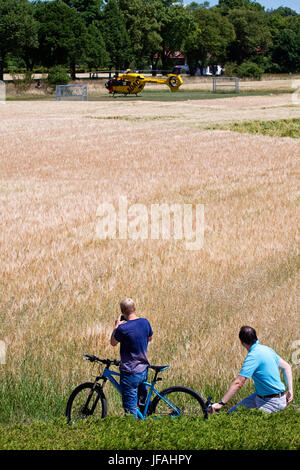 Garching, Allemagne. 30 Juin, 2017. Des cyclistes s'arrêter pour regarder un hélicoptère a atterri sur un emplacement pour un appel d'urgence Crédit : Luisa Fumi/Alamy Live News Banque D'Images