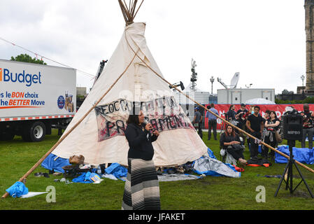 Ottawa, Canada - 30 juin 2017 : Candace jour Neveau, s'adresse à la foule rassemblée autour de la controversée ils tipi érigé en symbole de l'homme en raison d'indigènes qui a été refusé par la sécurité a ensuite déménagé plus près de la scène principale. Justin Trudeau, premier ministre a visité le teepee plus tôt dans la journée que son gouvernement a fait campagne sur l'idée d'améliorer le traitement des peuples autochtones. Crédit : Paul McKinnon/Alamy Live News Banque D'Images