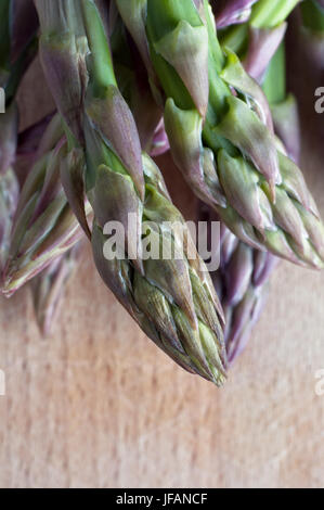 Un arrangement des asperges (tiges) en gros plan (macro) sur une vieille planche en bois, rayé. Orientation Portrait. Banque D'Images