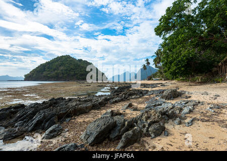 EL NIDO, Palawan, Philippines - Le 29 mars 2017:plage rocheuse avec quelques arbres à Las Cabanas Beach. Banque D'Images