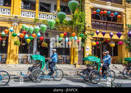 Les touristes sur un cyclo tour, lanternes colorées dans Hoi An, Vietnam Banque D'Images