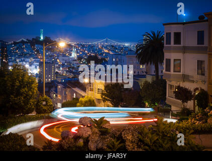Lombard Street, la rue la plus sinueuse "dans le monde", de nuit, avec des pistes de voitures passant, à San Francisco, Californie. Banque D'Images