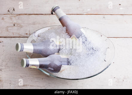 Trois bouteilles de bière en verre gelé immergé dans la glace Banque D'Images