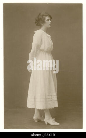 Carte postale tôt de l'ère WW1 jeune femme attrayante portant la jupe d'été blanche et le chemisier, avec des franges, une façon plus libérale de s'habiller pour les femmes avec la hemline surélevée montrant les chevilles, vers 1916,1917, Royaume-Uni Banque D'Images