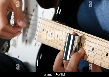 Joueur de guitare électrique effectuant chanson avec slider Banque D'Images