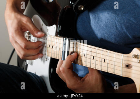 Joueur de guitare électrique effectuant chanson avec slider Banque D'Images