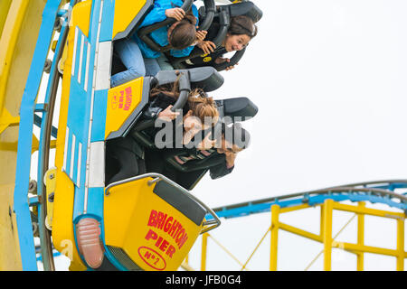 Turbo Coaster. Les gens à cheval sur le Turbo Coaster montagnes russes sur la jetée de Brighton à Brighton, East Sussex, Angleterre, Royaume-Uni. Banque D'Images