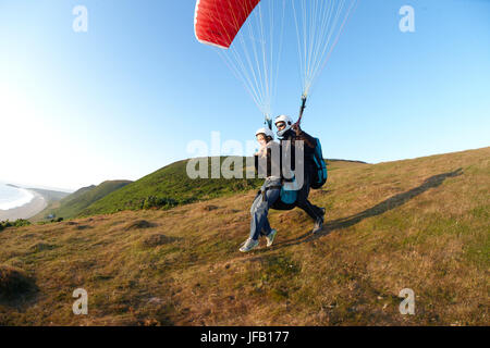 Décollage parapente en tandem au-dessus de la plage. Banque D'Images