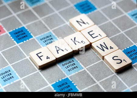 Une partie de Scrabble avec les lettres formant les mots 'Fausse News'. Le Scrabble est un jeu amusant et éducatif distribué dans le monde entier par Hasbro. Banque D'Images