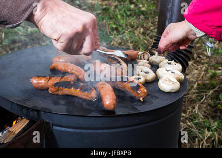 Griller la viande sur un poêle à bois Banque D'Images