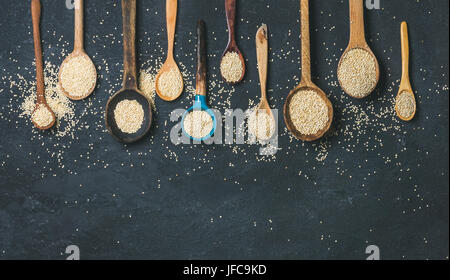 Les graines de quinoa dans les cuillères au fond de pierre noire, copy space Banque D'Images