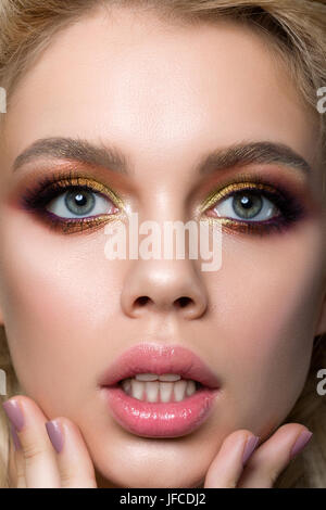 Close-up portrait of young surprised woman touching her face. Fille avec la bouche ouverte. Nouvelles inattendues ou vente concept. La mode moderne de fumée multicolore Banque D'Images