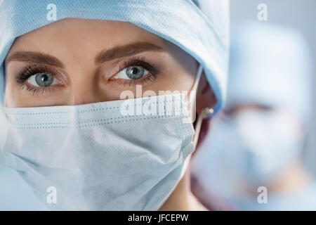 Close up portrait of female surgeon médecin portant masque de protection et le chapeau. Les soins de santé, l'éducation médicale, service médical d'urgence et de chirurgie d'hiver Banque D'Images