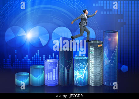 Businessman jumping over bar charts Banque D'Images