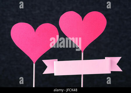 Conception d'artisanat faits à la main pour la mère, la saint valentin ou la journée de la femme carte. 2 coeurs rouges et ruban vide avec copie espace coupé de carton ou de papier. Banque D'Images