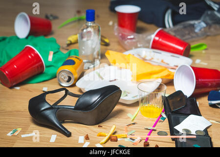 Fouillis après partie. Corbeille, des bouteilles, de la nourriture, des tasses et des vêtements sur le sol. Si vous quittez l'appartement en désordre après ou le lendemain matin. Horrible cha Banque D'Images