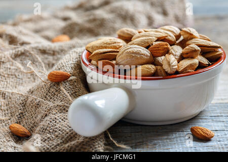 Amandes brutes dans un bol en céramique. Banque D'Images